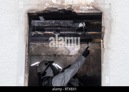 Nuremberg, Germany. 02 March 2019, Bavaria, Nürnberg: A forensic technician of the police in respiratory protective clothing inspects the ceiling of the burnt-out house. Five people died in a fire in a detached house in Nuremberg. Photo: Lino Mirgeler/dpa Credit: dpa picture alliance/Alamy Live News Stock Photo
