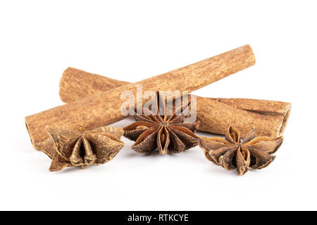 Group of three whole dry brown star anise fruit with two cinnamon sticks isolated on white background Stock Photo
