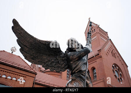 Statue of Archangel Michael with outstretched wings in front of the Roman Catholic Church of Saints Simon and Helena also known as the Red Church built in 1910 in the neo-Romanesque style located in the Upper Town the historical center of the city of Minsk, capital of Belarus Stock Photo