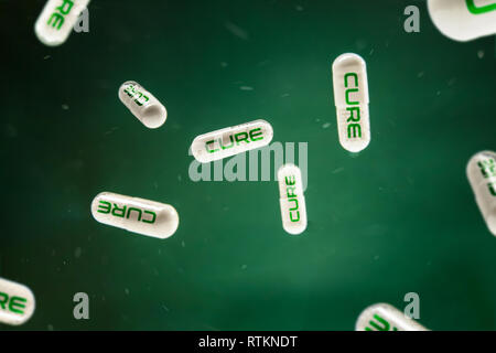 Pills with 'cure' sign hangs on the green background. Conception of new discovery in medicine. Stock Photo