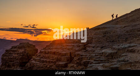 A group of people hiking in the Negev desert in southern Israel, at sunset time Stock Photo