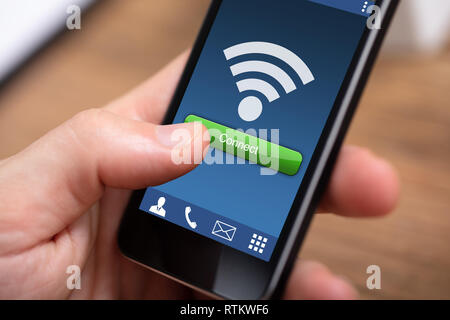 Close-up Of Person's Hand Holding Mobile Phone With Wireless Wireless Connection Stock Photo