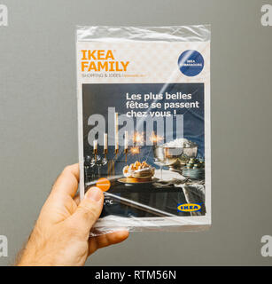 PARIS, FRANCE - NOV 19, 2017: Ikea Family advertising newsletter in male hand against gray background - featuring Christmas holiday shopping ideas  Stock Photo