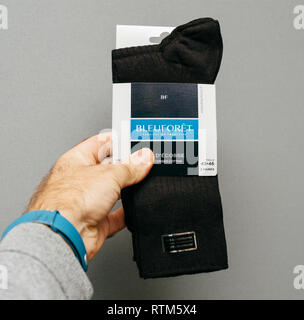 PARIS, FRANCE - NOV 10, 2017: Man holding French Bleuforet mercerised cotton new pair of socks against gray background Stock Photo