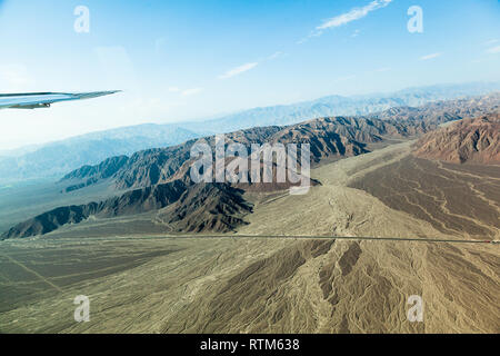 View from the window of an airplane of the relief of the desert and the lines that are formed by erosion in rainy seasons in the plateau of Nazca, Per Stock Photo