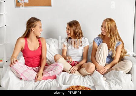 happy friends or teen girls eating pizza at home Stock Photo