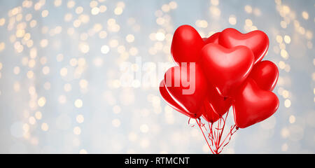 red heart shaped helium balloons on white Stock Photo