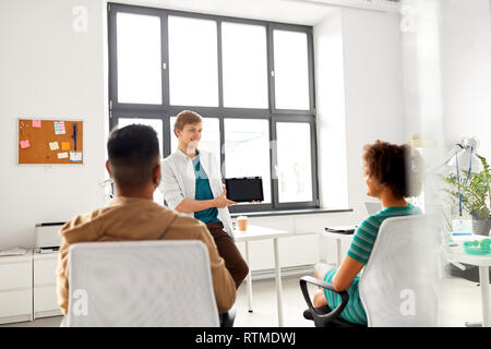 man showing tablet pc to creative team at office Stock Photo