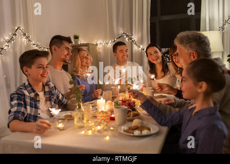 family with sparklers having dinner party at home Stock Photo