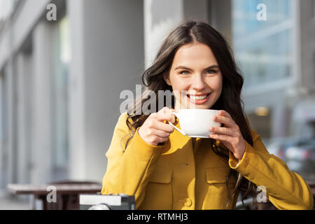 teenage girl drinking hot chocolate at city cafe Stock Photo