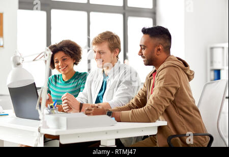 happy creative team with laptop working at office Stock Photo