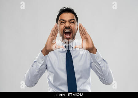 indian businessman screaming over grey Stock Photo
