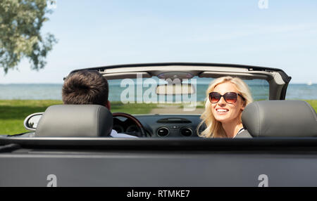 happy man and woman driving in cabriolet car Stock Photo