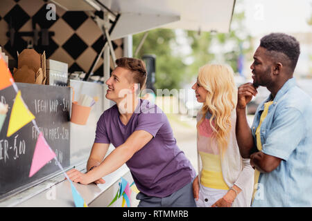 happy customers queue or friends at food truck Stock Photo