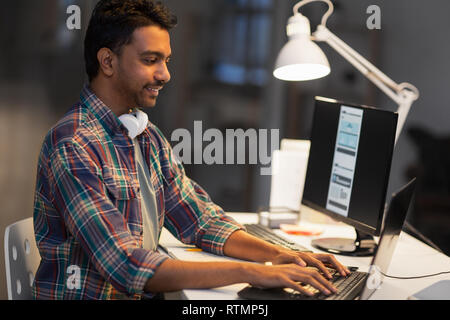 creative man with laptop working at night office Stock Photo