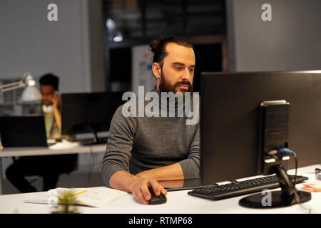 creative man with computer working at night office Stock Photo