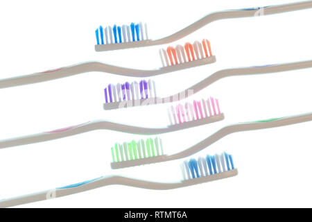 Horizontal side view shot of six colorful toothbrushes with white handles laid diagonally isolated on white. Stock Photo
