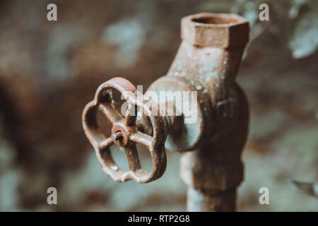 Old worn out water pipes. Broken hydraulic valve, crane. Old pipes of heating. Torn conduits. Large heat loss. Obsolete not efficient technologies in Stock Photo