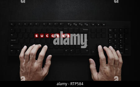 Success concept. Hand typing on computer keyboard and SUCCESS on red buttons Stock Photo
