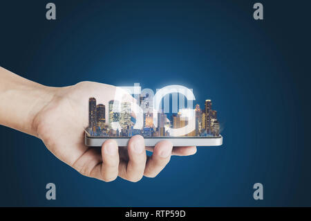 5G internet network technology, Hand holding mobile smart phone and buildings hologram with 5G internet network Stock Photo