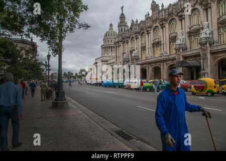 Havana, Cuba - 18 January 2013: A view of the streets of the city with cuban people. A street sweeper in the foreground. Stock Photo