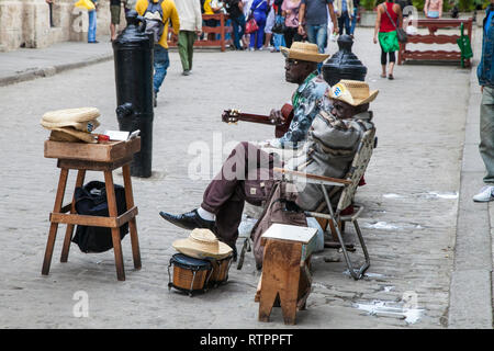 Havana, Cuba - 18 January 2013: A view of the streets of the city with cuban people. Street musicians take a break. Stock Photo