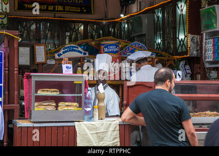 Havana, Cuba - 18 January 2013: A view of the streets of the city with cuban people. A tourist  waiting for his sandwich. Stock Photo