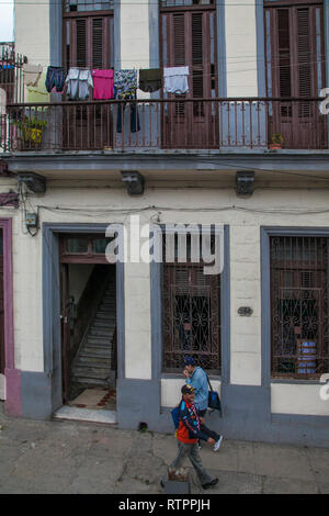 Havana, Cuba - 18 January 2013: A view of the streets of the city with cuban people. A view of the house with hanging laundry. Stock Photo