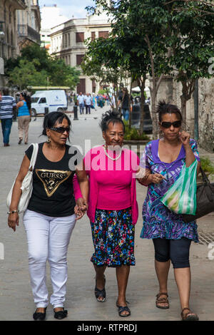 Havana, Cuba - 22 January 2013: A view of the streets of the city with cuban people. Three older women go and talk. Stock Photo
