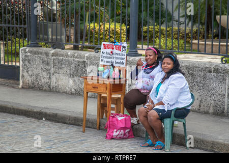 Havana, Cuba - 22 January 2013: A view of the streets of the city with cuban people. Two women sell cosmetics on the street. Stock Photo