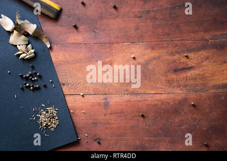 spices and herbs on a brown wooden board contain white pepper, ciander, pecan and orange leaf food seasoning background concept Stock Photo