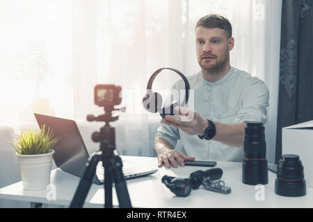 technology blogger recording headphone review in front of camera at home Stock Photo