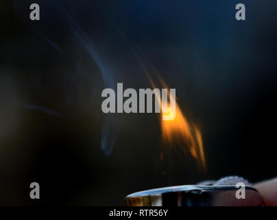 Lighter fire with dark background. Making fire with lighter. Stock Photo