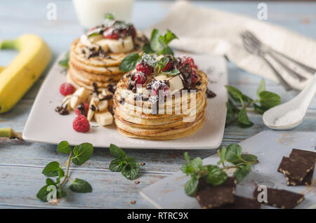 Beautiful and delish dessert, fresh pancakes with dark chocolate and fresh fruit with mint Stock Photo