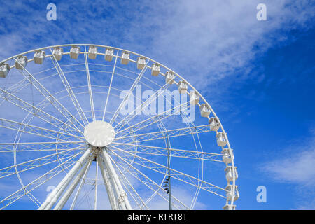 Close-up of the ferris wheel spinning and the blue sky as a background Stock Photo