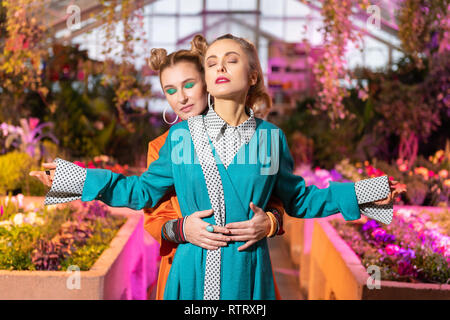 Nice young woman standing behind her friend Stock Photo