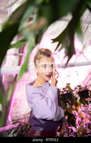 Nice pleasant young woman touching her face Stock Photo