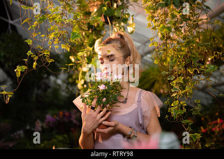 Nice young woman feeling the smell of roses Stock Photo