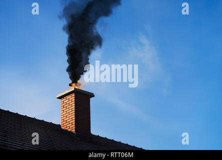 Chimney on fire with a black smoke coming out. Stock Photo