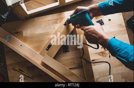 Carpenter man working with drill and furniture,fixing or repairing house.modern living concepts ideas Stock Photo