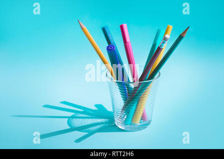 Colorful pen and pencil in glass with long shadow on pastel background.business creativity concept ideas Stock Photo