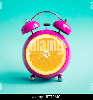Summer time concepts ideas with orange alarm clock on blue pastel background. Stock Photo