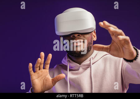 African professional boxer looking through the competition with his participation, using VR glasses, studying mistakes and tactic of opponent Stock Photo