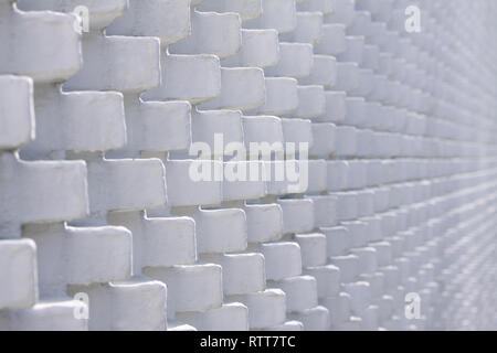 White brick wall in unusual pattern with bricks sticking out - selective focus Stock Photo