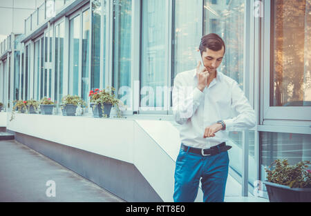 Young buisnessman talking on the phone by business center Stock Photo