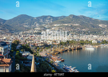 Young man looks at the Alanya port surrounded by mountains Stock Photo