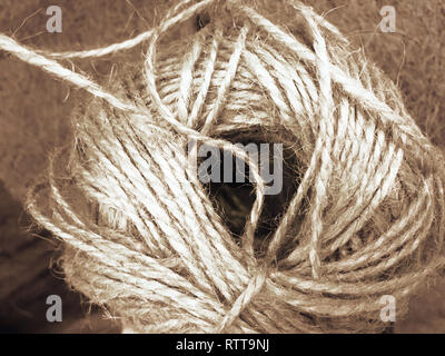 White Rope and Texture - Coiled white rope on a highly textured wooden background. Nautically themed studio close-up. Stock Photo