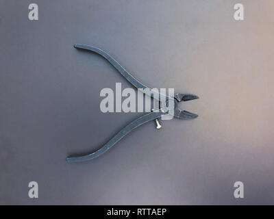 Side steel metal cutting nippers on gray and blue background Stock Photo