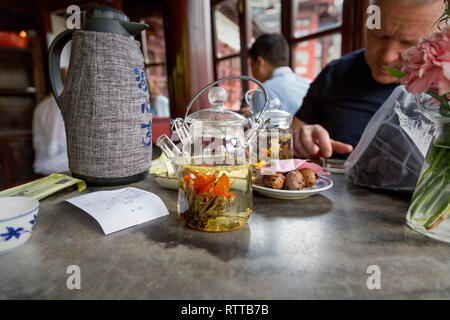 A customer enjoys a traditional Chinese tea and quail eggs at Huxinting Teahouse one of the most famous tea houses in China. Yu Garden, Old Shanghai. Stock Photo