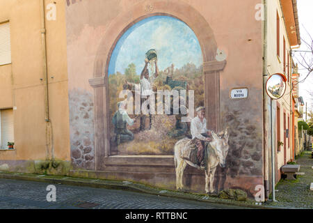 Sardinia Italy on December 27, 2019: Murals painted on houses in the streets of Tinnura depicting moments of rural and village life Stock Photo